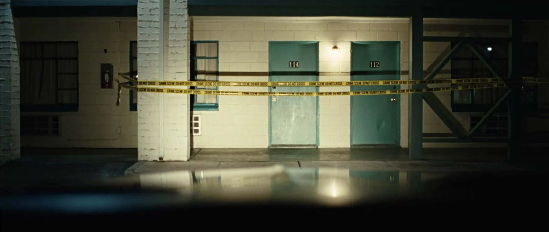Police tape cuts across the symmetry of an empty corridor.