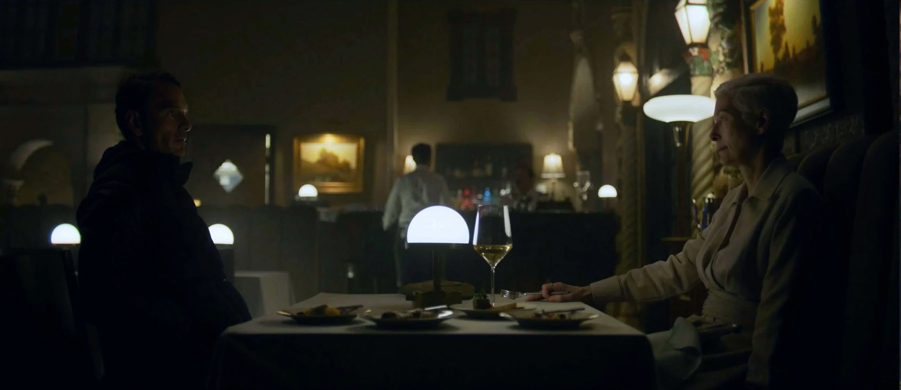A man and a woman sit opposite each other at a restaurant table.